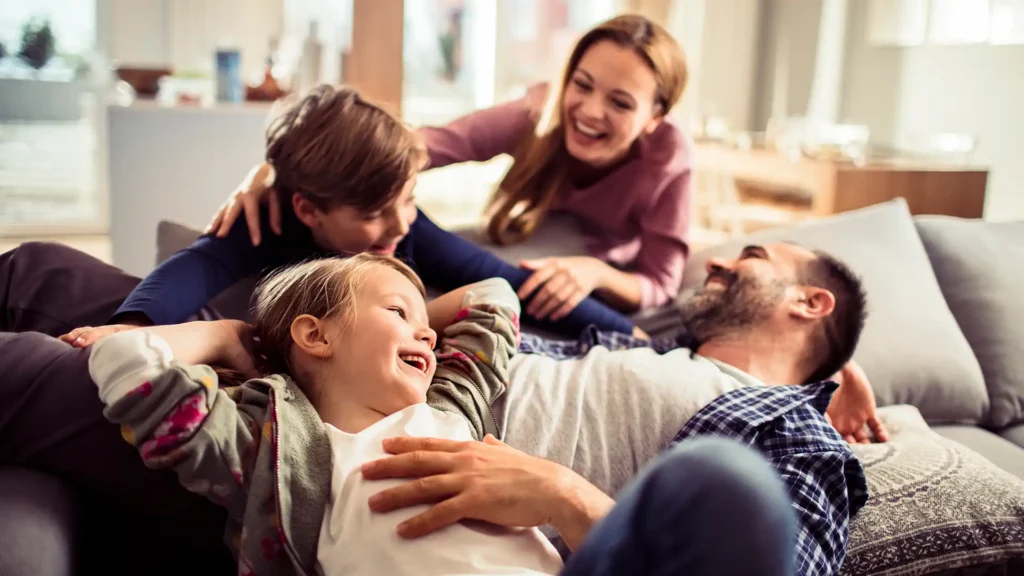 Happy young family relaxing on the couch together at home