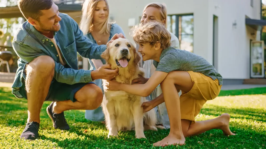 Smiling family with happy dog in backyard