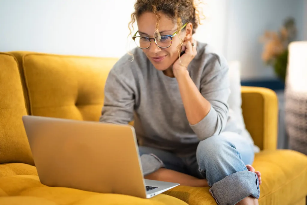Woman sitting on a couch using laptop