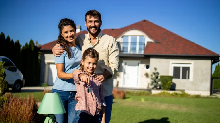 Happy family standing in front of their new rented home ready to move in