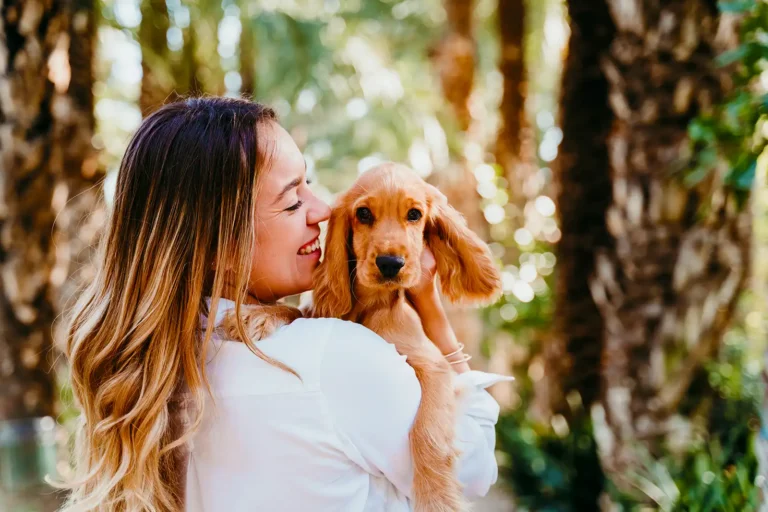 Woman playing with her dog on the grass in a pet-friendly dog park