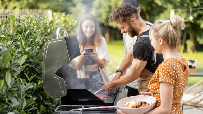 Backyard BBQ Ideas: Happy young friends hanging out together, grilling vegetables and meat on a grill